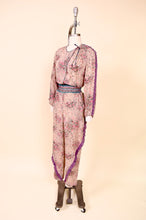 Load image into Gallery viewer, 1970s red and white floral dress is shown from the side. This dress has a tie at the waist.
