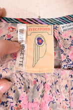 Load image into Gallery viewer, Closeup of 1970&#39;s red and white floral dress label. The label reads Made in USA, 50% polyester, 50% cotton, Size 14, Sears.
