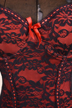 Load image into Gallery viewer, close up of black lace fabric and red bow detail on center bust
