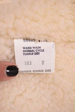 Load image into Gallery viewer, Tan corduroy Levi&#39;s vest care label is shown up close. The care label has wash instructions.
