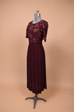 Load image into Gallery viewer, Vintage nineties burgundy maxi dress is shown from the side. This dress has a long pleated skirt.
