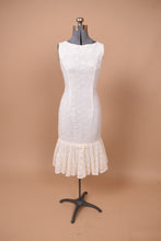 Load image into Gallery viewer, Vintage white lace midi length sleeveless 60s party dress is shown from the front. This dress is tight with flattering darts on the front of the bodice.
