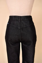 Load image into Gallery viewer, Vintage high rise black denim flare pants by Jordache are shown in close up. These high rise flare pants have belt loops.
