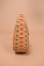 Load image into Gallery viewer, Vintage woven rattan bag is shown from the side. This bag has pink and green woven rattan.
