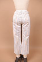 Load image into Gallery viewer, Vintage white low rise striped flare pants by Theory are shown in close up. These pants have a cropped flare fit.