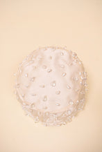 Load image into Gallery viewer, Vintage white satin beaded turban by Christian Dior is shown from above. This sparkly beaded hat is by Christian Dior.