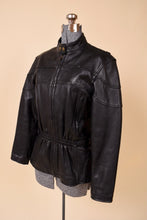 Load image into Gallery viewer, Vintage black leather motorcycle jacket is shown from the side. This jacket has an elastic waist. 
