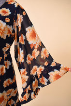 Load image into Gallery viewer, Vintage designer Betsey Johnson navy blue and orange flower print mini dress is shown in close up. This dress has wide bell sleeves with a ruffle hem.
