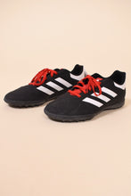 Load image into Gallery viewer, Vintage black and white Adidas soccer cleats are shown from the side. These soccer cleats have red laces. 
