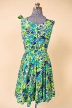 Load image into Gallery viewer, Vintage blue and green flower print dress with a full pleated skirt is shown from the back.
