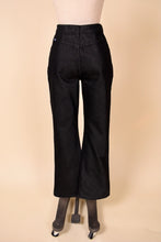 Load image into Gallery viewer, Vintage black denim bell bottom jeans are shown from the back. These jeans are by the brand Jordache. 
