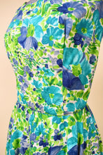 Load image into Gallery viewer, Vintage sixties green painted floral fit and flare dress is shown in close up. 
