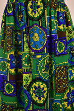 Load image into Gallery viewer, Vintage 1970s blue, green and yellow geometric print maxi skirt is shown in close up. This 70&#39;s XL size skirt has a stained glass print.
