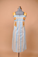 Load image into Gallery viewer, Vintage blue and orange striped dress is shown from the back. This dress has two pleats down the front.
