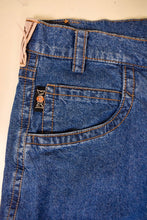 Load image into Gallery viewer, Vintage 80s navy denim tapered boyfriend jeans are shown in close up. This high rise jeans have a little tag that reads Emmegi.

