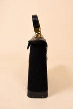 Load image into Gallery viewer, Vintage black 60&#39;s Enid Collins bucket purse is shown from the side. This bag has a top handle. 
