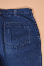 Load image into Gallery viewer, Vintage navy blue dark wash denim jeans are shown in close up. These seventies high waisted flare jeans have darts at the back.
