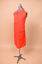 Load image into Gallery viewer, Vintage 70s red smock dress shown from the side. This dress has two front pockets with navy floral accents.