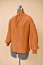 Load image into Gallery viewer, Vintage eighties orange high neck blouse is shown from the side. This blouse has puffed sleeves.
