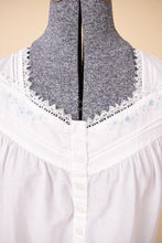Load image into Gallery viewer, Vintage white cotton pajama mini dress is shown in close up. This dress has blue embroidered flowers on the bust. 

