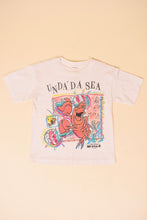 Load image into Gallery viewer, Vintage white cropped single stitch 80's Unda Da See little mermaid shirt is shown from the front.