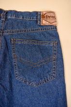 Load image into Gallery viewer, Vintage navy denim blue thin boyfriend style jeans are shown in close up. These jeans have back pockets with brown stitching. 
