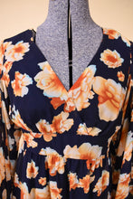 Load image into Gallery viewer, Vintage 2000's Betsey Johnson blue and orange flower print mini dress is shown in close up. This dress has a crossover v neckline.