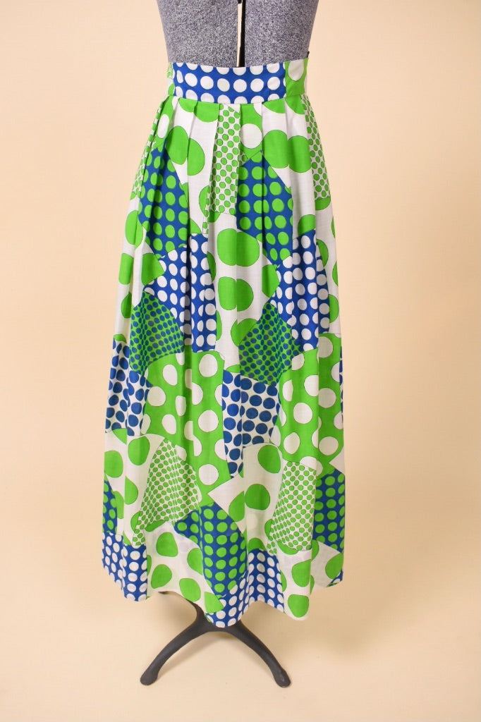 Vintage 1960's green and blue patchwork pattern polka dot maxi skirt is shown from the front. This skirt has a high waisted fit. 