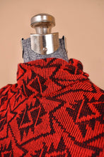 Load image into Gallery viewer, Vintage eighties black and red geometric patterned knit dress is shown in close up. This dress has a slouchy turtleneck fit.
