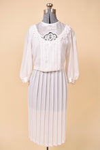 Load image into Gallery viewer, Vintage 1980&#39;s white pleated midi dress is shown from the front. This sheer mutton sleeve dress has a lace bib detail.
