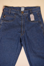 Load image into Gallery viewer, Vintage 80s navy blue denim worn in boyfriend jeans are shown from the front. These jeans have a metal button at the waist. 
