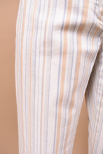 Load image into Gallery viewer, Vintage Y2K designer low rise stripe trousers by Theory are shown in close up. These pants have a vertical stripe pattern with cream, blue, grey, and tan stripes.