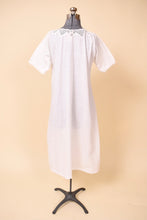 Load image into Gallery viewer, Vintage maxi length white cotton short sleeve nightgown dress is shown from the back. This antique night dress has a crochet neckline with a ribbon accent. 
