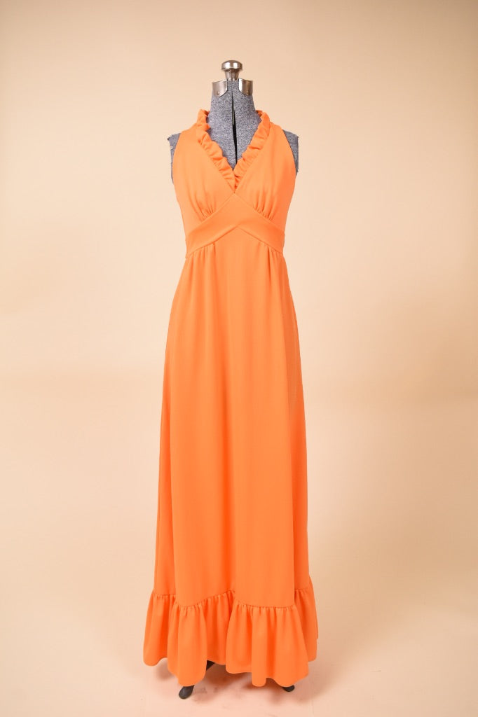 Vintage orange polyester 1970's ruffled maxi length gown is shown from the front. This dress has an empire waist.