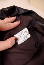 Load image into Gallery viewer, Vintage low rise leather pants are shown in close up. These dark brown leather pants are tagged a size 6.