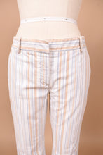 Load image into Gallery viewer, Vintage cotton designer Theory low rise cropped pants are shown in close up. These pants are white with tan and blue vertical stripes. 
