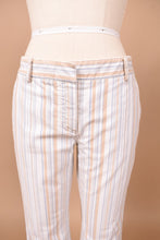 Load image into Gallery viewer, Vintage cotton designer Theory low rise cropped pants are shown in close up. These pants are white with tan and blue vertical stripes.