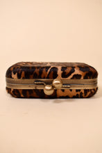 Load image into Gallery viewer, Vintage animal print pony hair clutch bag is shown from the side. This bag has two circular brassy toggles at the close. 
