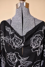 Load image into Gallery viewer, Vintage cold shoulder sheer black beaded blouse is shown in close up. This blouse has beaded white roses. 
