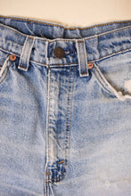Load image into Gallery viewer, Vintage eighties orange tab medium wash distressed short are shown in close up. 

