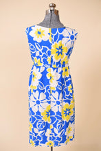 Load image into Gallery viewer, Vintage sixties blue, yellow, and white flower print midi length dress is shown from the back. 

