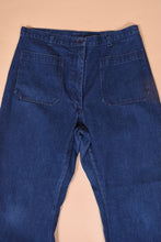 Load image into Gallery viewer, Vintage dark wash denim seventies jeans are shown in close up. These jeans have a high waisted fit with big square utility pockets. 
