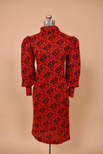 Load image into Gallery viewer, Vintage red and black knit 1980&#39;s dress is shown from the front. This dress has puffed sleeves.
