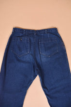 Load image into Gallery viewer, Vintage 70&#39;s dark wash size 34 waist jeans are shown in close up. These jeans have two back pockets.
