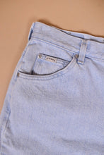 Load image into Gallery viewer, Vintage light wash sky blue denim mom jeans by Riders are shown in close up. These 90&#39;s jeans have a Riders brand tag on the front pocket. 
