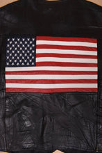 Load image into Gallery viewer, Vintage patchwork black leather vest is shown in close up. This vest has a leather red, white, and blue American flag on the back.