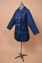 Load image into Gallery viewer, Vintage navy blue quilted puffer coat is shown from the side. This jacket has a collar.
