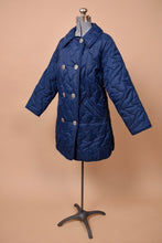 Load image into Gallery viewer, Vintage navy blue quilted puffer coat is shown from the side. This jacket has a collar.