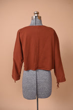 Load image into Gallery viewer, Vintage burnt orange western long sleeve cropped top is shown from the back. This shirt has fringe. 
