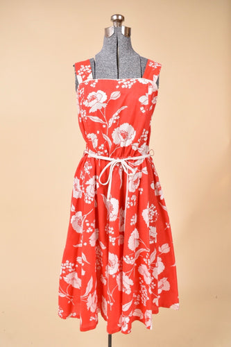 1970's red and white floral dress is shown from the front. The dress has wide straps.